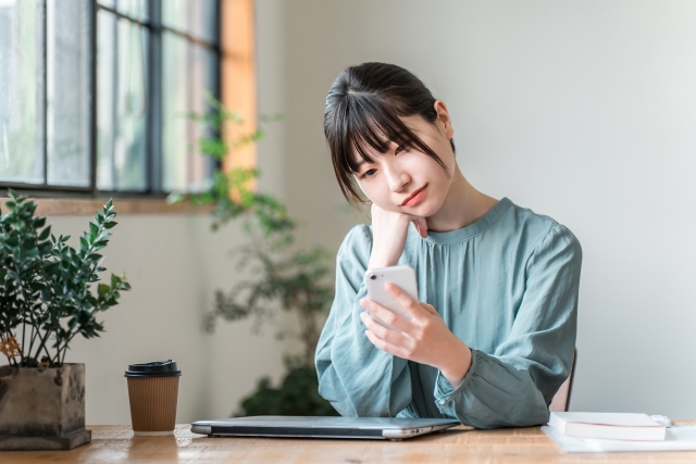 【初心者向け】Androidのキャッシュとは？削除の影響と安全な消し方 スマホを見て悩む女性